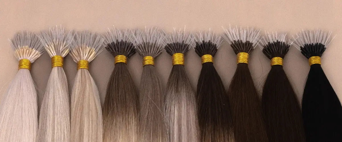 Hair extension samples from gdollshair showing a color gradient from platinum blonde to jet black, with gold bands securing each bundle.