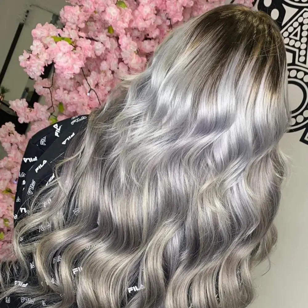 Long flowing ash blonde hair with dimensional highlights and soft waves achieved with G-Dolls hair extensions